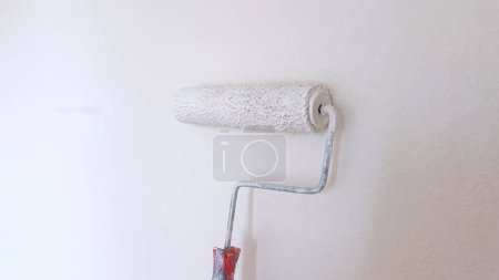 Foto de Parcialmente pintado pared con un rodillo de pintura blanca, mostrando el proceso de renovación de la pared y la mejora del hogar. - Imagen libre de derechos
