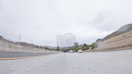 Foto de En medio de un día lluvioso de invierno, conducir en HWY 134 cerca de Los Ángeles, California, captura la atmósfera a través de lentes cubiertas de gotas de lluvia, agregando una perspectiva única y malhumorada al viaje. - Imagen libre de derechos