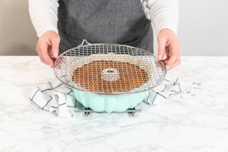 Präzise wird das Kuchenbündel vorsichtig aus der Pfanne genommen - auf ein rundes Kühlgestell gelegt, das es für eine makellose Präsentation und köstlichen Genuss vorbereitet..