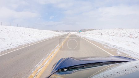 Photo for Navigating a frontage road post-winter storm offers a serene drive. The surrounding landscape, blanketed in snow, contributes to the peaceful and picturesque environment, enhancing the driving - Royalty Free Image