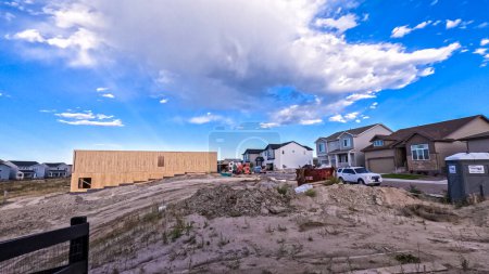 Photo for Denver, Colorado, USA-August 30, 2023-New residential neighborhood reveals the stark contrast between the raw wooden frame of an under-construction building and the completed homes in the background - Royalty Free Image