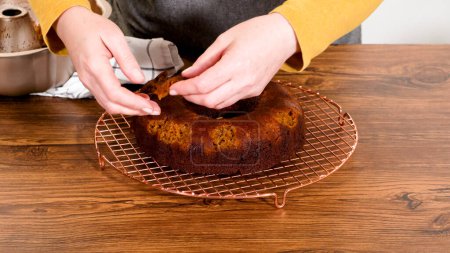 Foto de La torta de pan de jengibre facilita suavemente su molde en un estante de alambre, preparado para una llovizna de glaseado de caramelo dulce. - Imagen libre de derechos