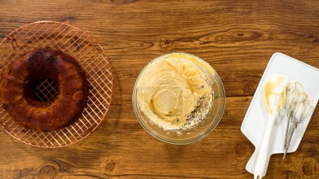 Téléchargez les photos : Pose plate. Fouetter le glaçage à la crème au beurre au caramel salé pour le gâteau bundt au pain d'épice. - en image libre de droit