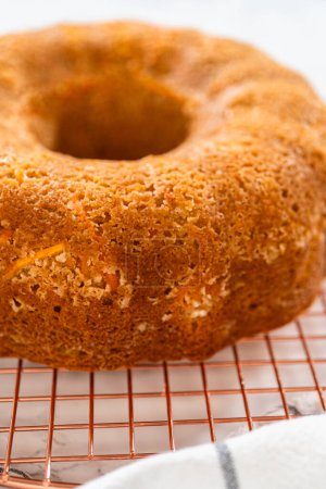 Téléchargez les photos : Le gâteau Bundt aux carottes fraîchement cuit est laissé refroidir sur le comptoir de la cuisine, remplissant l'air d'arômes délicieux. - en image libre de droit