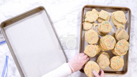 Photo for Flat lay. With precision, the woman is carefully arranging the sugar cookies, filled with dough-mixed sprinkles, into a rustic brown paper box. - Royalty Free Image