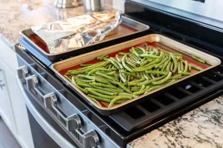 Photo for Watch as fresh green beans are beautifully roasted to perfection on a baking sheet with a silicone mat, adding a burst of flavor to your meal. - Royalty Free Image