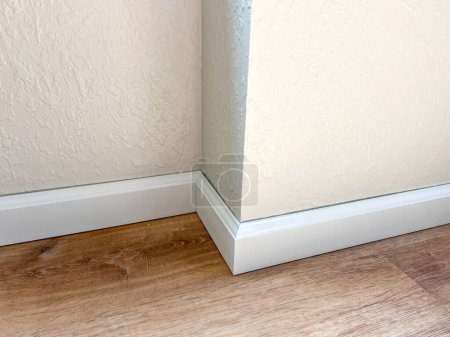 Photo for Witness the professional installation of vinyl baseboards in a stylish modern home, adding a sleek finishing touch to the interior design. - Royalty Free Image
