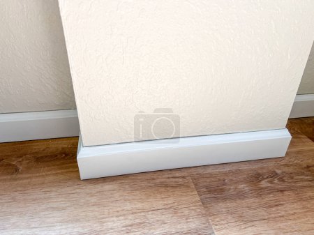 Witness the professional installation of vinyl baseboards in a stylish modern home, adding a sleek finishing touch to the interior design.