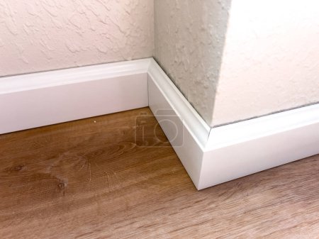 Photo for Witness the professional installation of vinyl baseboards in a stylish modern home, adding a sleek finishing touch to the interior design. - Royalty Free Image