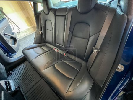 Photo for Castle Rock, Colorado, USA-March 14, 2024-The interior of a Tesla Model 3, featuring its premium black seats and modern dashboard, receives a meticulous cleaning in the garage of a private residence. - Royalty Free Image