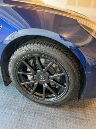 Foto de Castle Rock, Colorado, Estados Unidos-Marzo 14, 2024-Un Tesla Model 3 azul brillante se encuentra en el garaje bien cuidado de una casa unifamiliar, su diseño elegante acentuado por el cuidado suave de un lavado de autos en casa. - Imagen libre de derechos