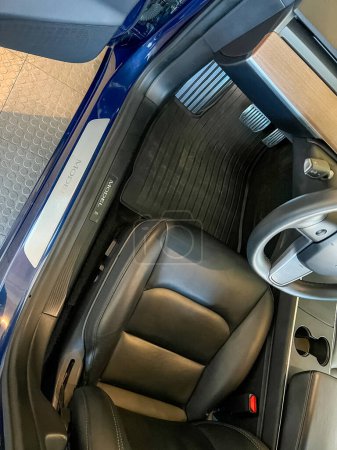 Foto de Castle Rock, Colorado, Estados Unidos-14 de marzo de 2024-El interior de un Tesla Model 3, con sus asientos negros premium y su moderno salpicadero, recibe una meticulosa limpieza en el garaje de una residencia privada. - Imagen libre de derechos