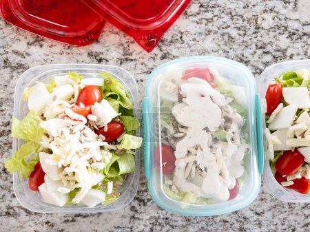 Photo for Containers filled with salad and dressing, prepared for convenient lunchtime meal prep. - Royalty Free Image