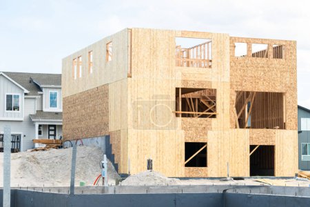 Foto de Un sitio de construcción en curso en los suburbios, con la etapa de fundación de una casa unifamiliar. - Imagen libre de derechos