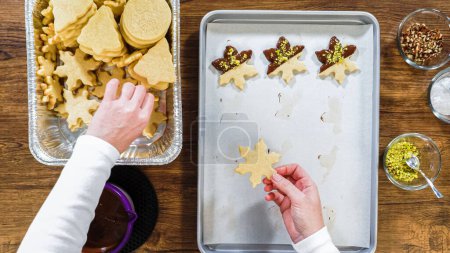 Photo for Flat lay. Creating snowflake-shaped cutout sugar cookies, dipped in chocolate, and adorned with different toppings. - Royalty Free Image