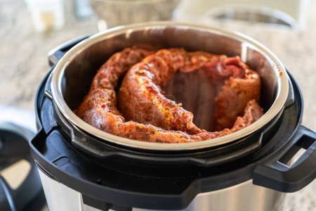 In a sleek modern kitchen, we are adding an extra layer of flavor to succulent baby back ribs by infusing them with a medley of spices in a multicooker-a mouthwatering feast in the making.