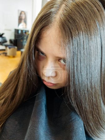 Gentle hands maneuver a hair dryer through a young girls newly cut hair, showcasing the drying process after a meticulous trim. The warmth of the dryer breathes life into her locks, as they transform