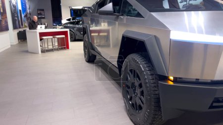 Photo for Colorado Springs, Colorado, USA-March 23, 2024-The futuristic Tesla Cybertruck takes center stage in the showroom of a Tesla store, with interested visitors and sleek car designs in the backdrop, all - Royalty Free Image
