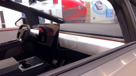 Téléchargez les photos : Colorado Springs, Colorado, États-Unis-23 mars 2024-Le futuriste Tesla Cybertruck prend le devant de la scène dans la salle d'exposition d'un magasin Tesla, avec des visiteurs intéressés et des conceptions de voitures élégantes en toile de fond, tous - en image libre de droit