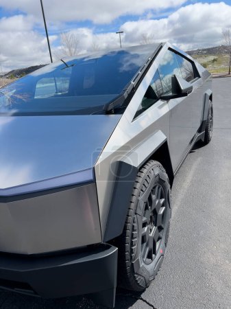Photo for Denver, Colorado, USA-March 28, 2024-The front profile of a Tesla Cybertruck is displayed, showcasing its futuristic lines and robust design, parked in an open-air parking lot with a dynamic sky - Royalty Free Image