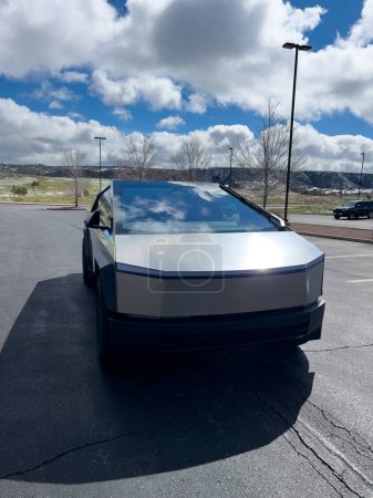 Foto de Denver, Colorado, Estados Unidos-28 de marzo de 2024-Se muestra el perfil frontal de un Cybertruck Tesla, mostrando sus líneas futuristas y su diseño robusto, estacionado en un estacionamiento al aire libre con un cielo dinámico - Imagen libre de derechos