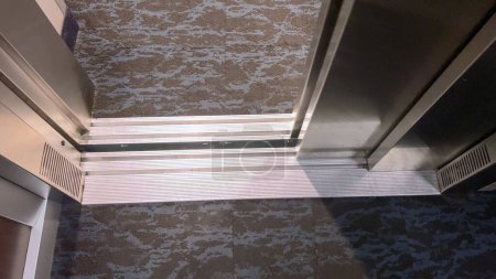 Die detaillierte Ansicht einer Aufzugsschwelle, an der die Kabine auf den Gebäudeboden trifft, unterstreicht den Übergangsraum, der ein sicheres Ein- und Aussteigen erleichtert.