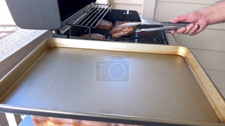 Photo for Several thick steaks with grill marks cooking to perfection on an outdoor grill, capturing the essence of a sunny barbecue day. - Royalty Free Image