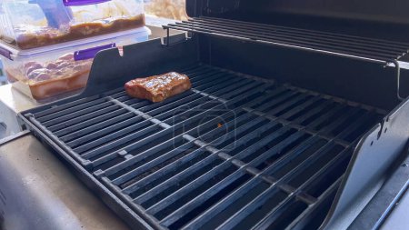 Téléchargez les photos : Plusieurs steaks épais avec des marques de grill cuisiner à la perfection sur un gril extérieur, capturant l'essence d'une journée de barbecue ensoleillée. - en image libre de droit