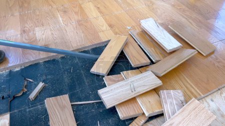 Téléchargez les photos : Un ensemble dispersé de planches de bois franc se trouve sur un plancher partiellement achevé, soulignant le travail en cours d'un projet de rénovation domiciliaire axé sur l'installation de nouveaux planchers de bois. - en image libre de droit