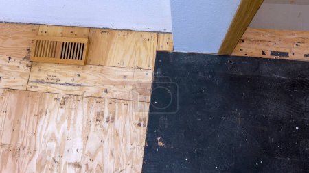 Téléchargez les photos : Un ensemble dispersé de planches de bois franc se trouve sur un plancher partiellement achevé, soulignant le travail en cours d'un projet de rénovation domiciliaire axé sur l'installation de nouveaux planchers de bois. - en image libre de droit