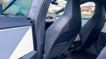 Téléchargez les photos : Une perspective de conducteur à l'intérieur du Cybertruck Tesla, mettant en valeur son intérieur spacieux et minimaliste avec un grand écran tactile et un volant futuriste, sur fond de paysage - en image libre de droit