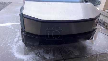 Photo for Denver, Colorado, USA-April 28, 2024- The front end of a Tesla Cybertruck is being meticulously cleaned using a high-pressure washer, showcasing the effectiveness of detailed vehicle maintenance and - Royalty Free Image