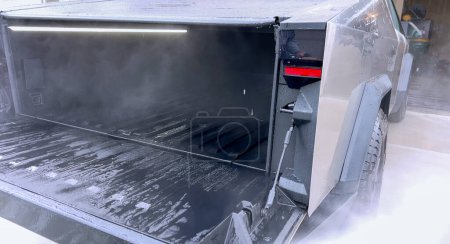 Photo for Denver, Colorado, USA-April 28, 2024- This image captures a Tesla Cybertruck undergoing a thorough cleaning, focusing on the high-pressure washing of its cargo bed, demonstrating the maintenance of - Royalty Free Image