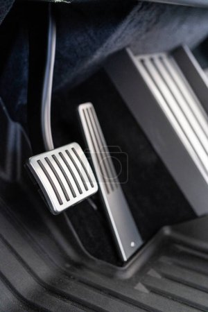 Photo for Denver, Colorado, USA-May 5, 2024-This image features a close-up view of the aluminum accelerator and brake pedals alongside the metal floor mat in a Tesla Cybertruck, highlighting the vehicle sleek - Royalty Free Image