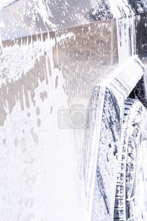 Téléchargez les photos : Denver, Colorado, USA-5 mai 2024-Cette image capture l'eau savonneuse qui coule magnifiquement sur le côté métallique et angulaire d'un Cybertruck Tesla lors d'un lavage. Le gros plan met en valeur les lignes épurées et - en image libre de droit