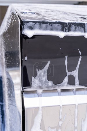 Foto de Denver, Colorado, USA-May 5, 2024-Esta imagen captura una vista detallada de las suciedades de jabón que se acumulan y gotean en el borde de una ventana de Tesla Cybertruck durante un lavado, resaltando el vehículo distinto - Imagen libre de derechos