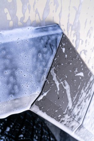 Foto de Denver, Colorado, USA-May 5, 2024-Esta imagen cuenta con una vista de cerca de la rueda del Cybertruck Tesla y el diseño del cuerpo angular cubierto de jabón y agua durante un lavado de autos a fondo, destacando la - Imagen libre de derechos