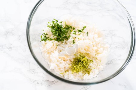 Cilantro Lime Rice. Mixing ingredients in a glass mixing bowl to prepare cilantro lime rice.