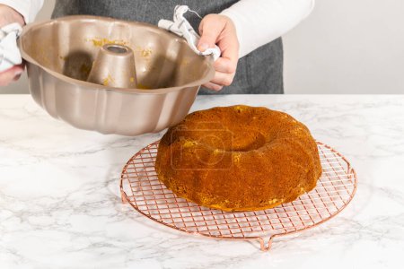 Cooling freshly baked pumpkin bundt cake on the kitchen counter.