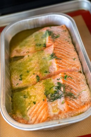 Discover the mouthwatering journey of salmon as its cooked to perfection in an oven, nestled in a foil tray, adorned with rich butter and tantalizing spices.