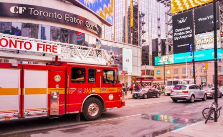 Photo for Toronto, Canada - 07 01 2022: Red Toronto Fire Services Spartan Gladiator Classic MFD Ladder truck on Younge Dundas intersection in front of CF Toronto Eaton Centre building in downtown Toronto. - Royalty Free Image