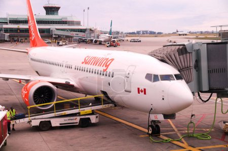 Photo for Montreal, Quebec, Canada - 07 04 2022 : Boeing 737 MAX 8 jet airliner of Sunwing Airlines parked in the airport of Montreal. Sunwing Airlines Inc., a Canadian low-cost airline was acquired by WestJet - Royalty Free Image
