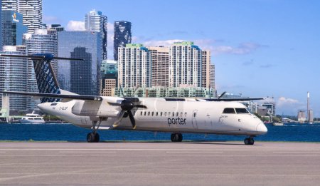 Téléchargez les photos : Toronto, Ontario, Canada - 08 11 2023 : White De Havilland Canada Dash 8 Avion de ligne Q400 à turbopropulseurs de Porter Airlines assis sur l'aire de trafic de l'aéroport Billy Bishop de Toronto - en image libre de droit
