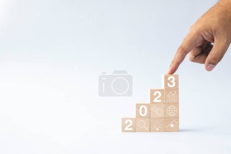 Photo for 2023 business growing growth concept to success. finger tapping woods block step with icon concept about business strategy, Action plan, Goal and target, hand stack, project, vision. - Royalty Free Image