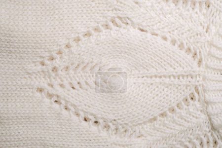 A detailed view of a white knitted blanket, showcasing intricate patterns and textures up close.