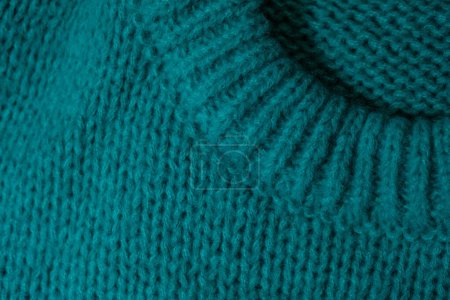 Detailansicht eines blauen Pullovers mit einem Loch in der Mitte.