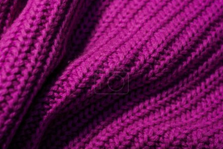 This close-up shot showcases a detailed purple knitted blanket, revealing intricate patterns and textures.
