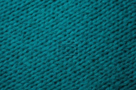 Detailed close-up shot of a textured blue knitted material, showcasing intricate knit patterns and varying shades of blue.