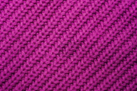 Vue détaillée d'un matériau tricoté violet vif, mettant en valeur des motifs et des textures complexes de près.