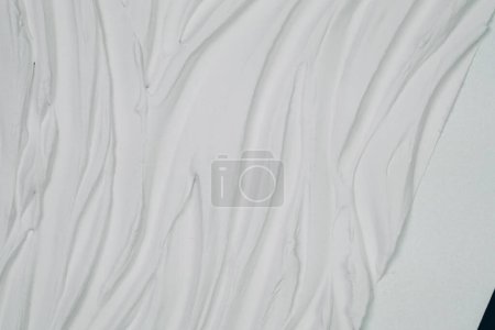 Eine extreme Nahsicht auf ein einzelnes Blatt weißes Papier, das seine Textur, Fasern und alle sichtbaren Details auf der Oberfläche zeigt.